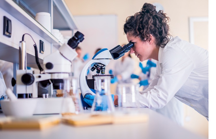 Scientist in lab doing research and using lab machines, test tubes, microscope and every laboratory equipment