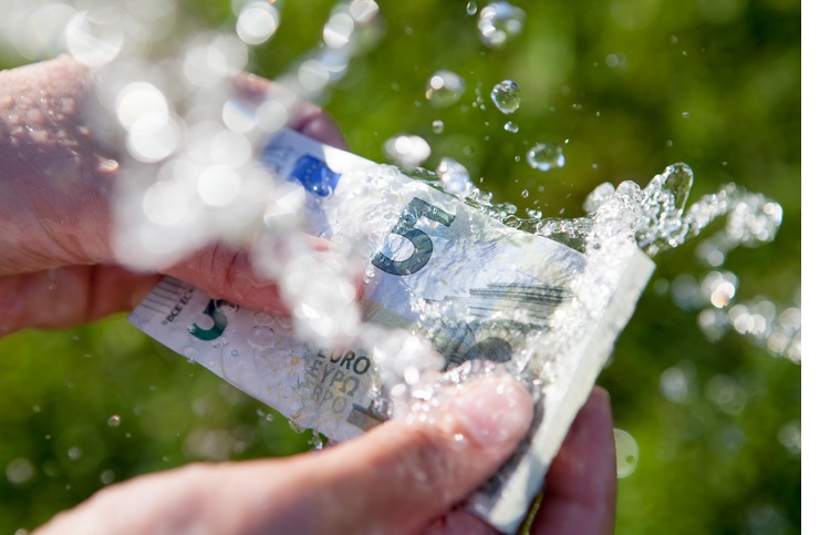 Two hands washing 5 euro banknote clean