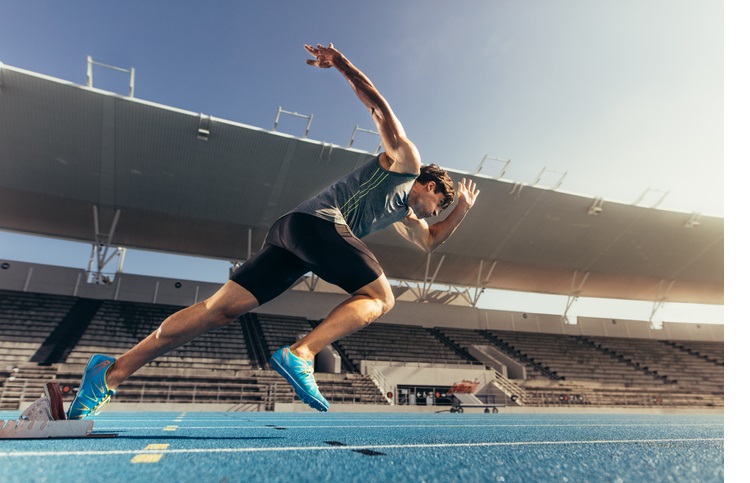 Sprinter taking off from starting block on running track