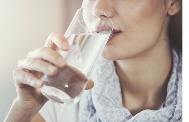Young woman drinking pure glass of water