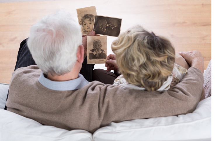 Senior marriage sitting on the sofa and looking at old photos