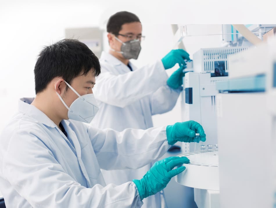 Labormitarbeiter mit Maske und Handschuhen führt Test durch