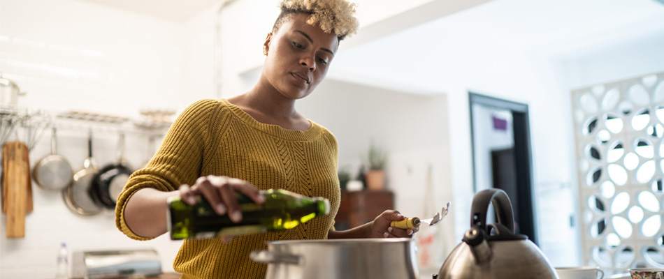 Frau kocht mit Olivenöl