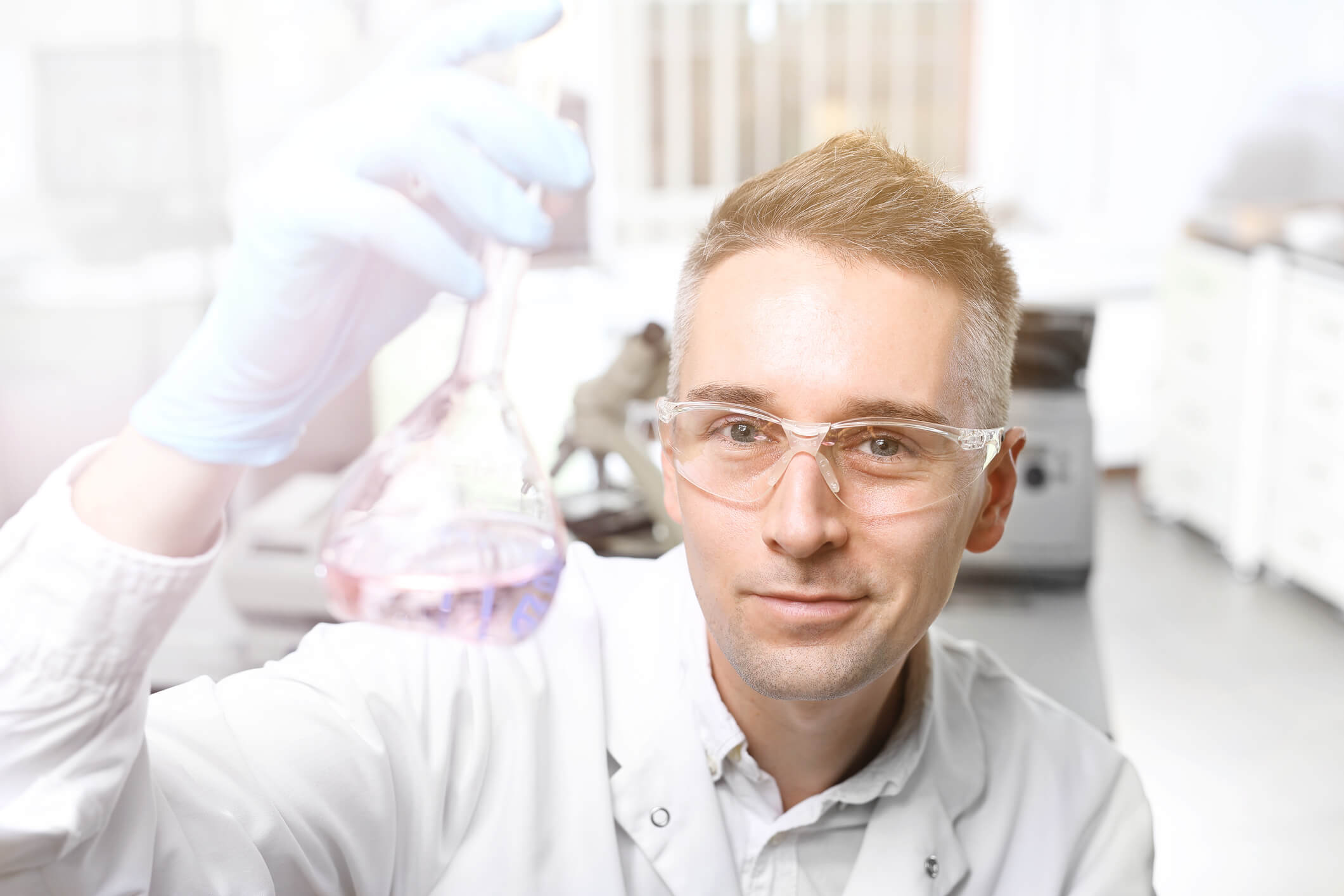 Lab man holding test tube with solution 