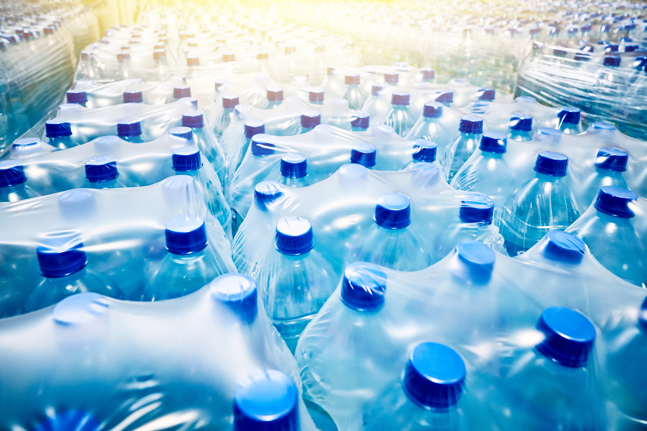 Many packaged blue mineral water bottles