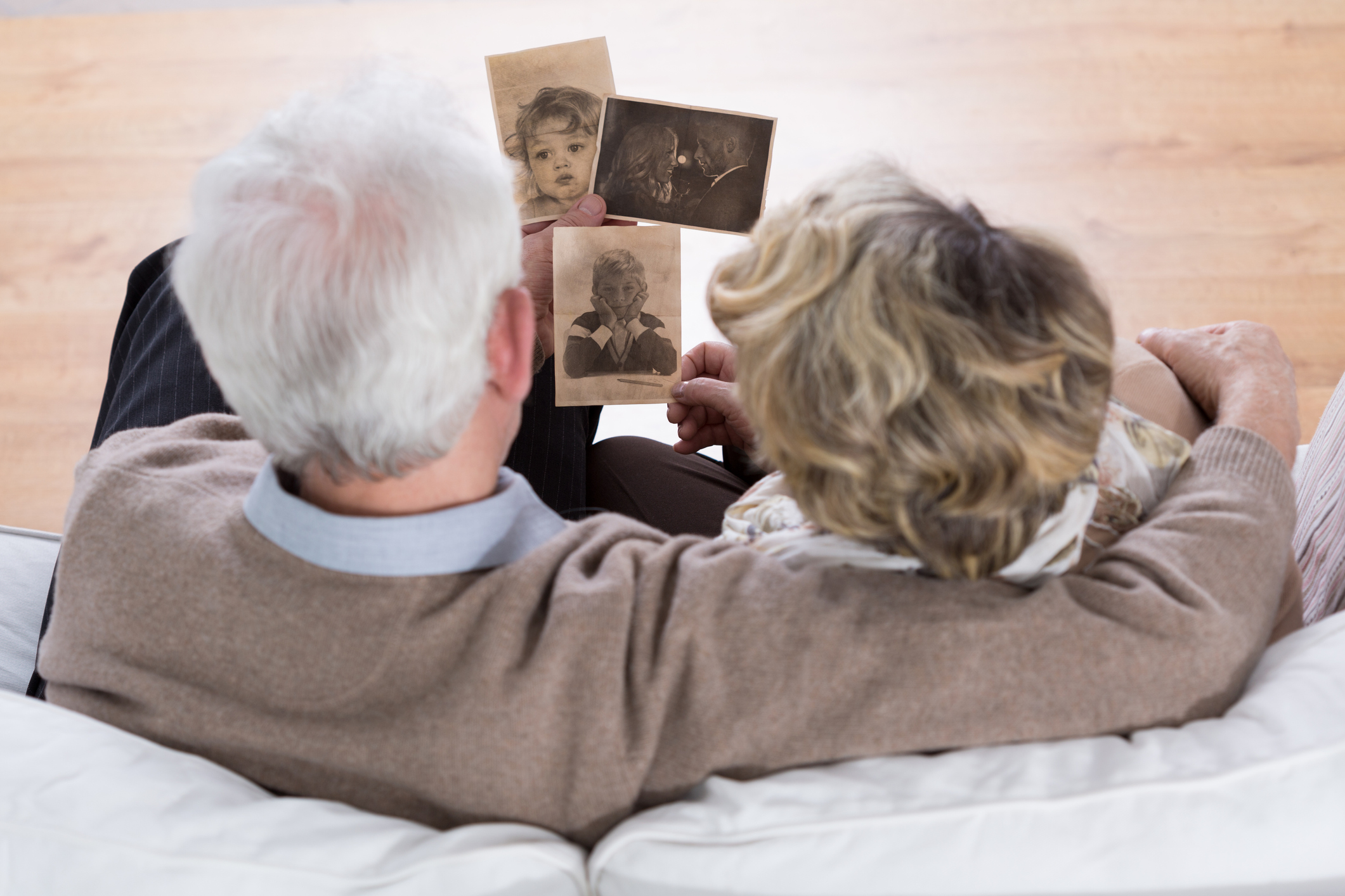 Senior marriage sitting on the sofa and looking at old photos