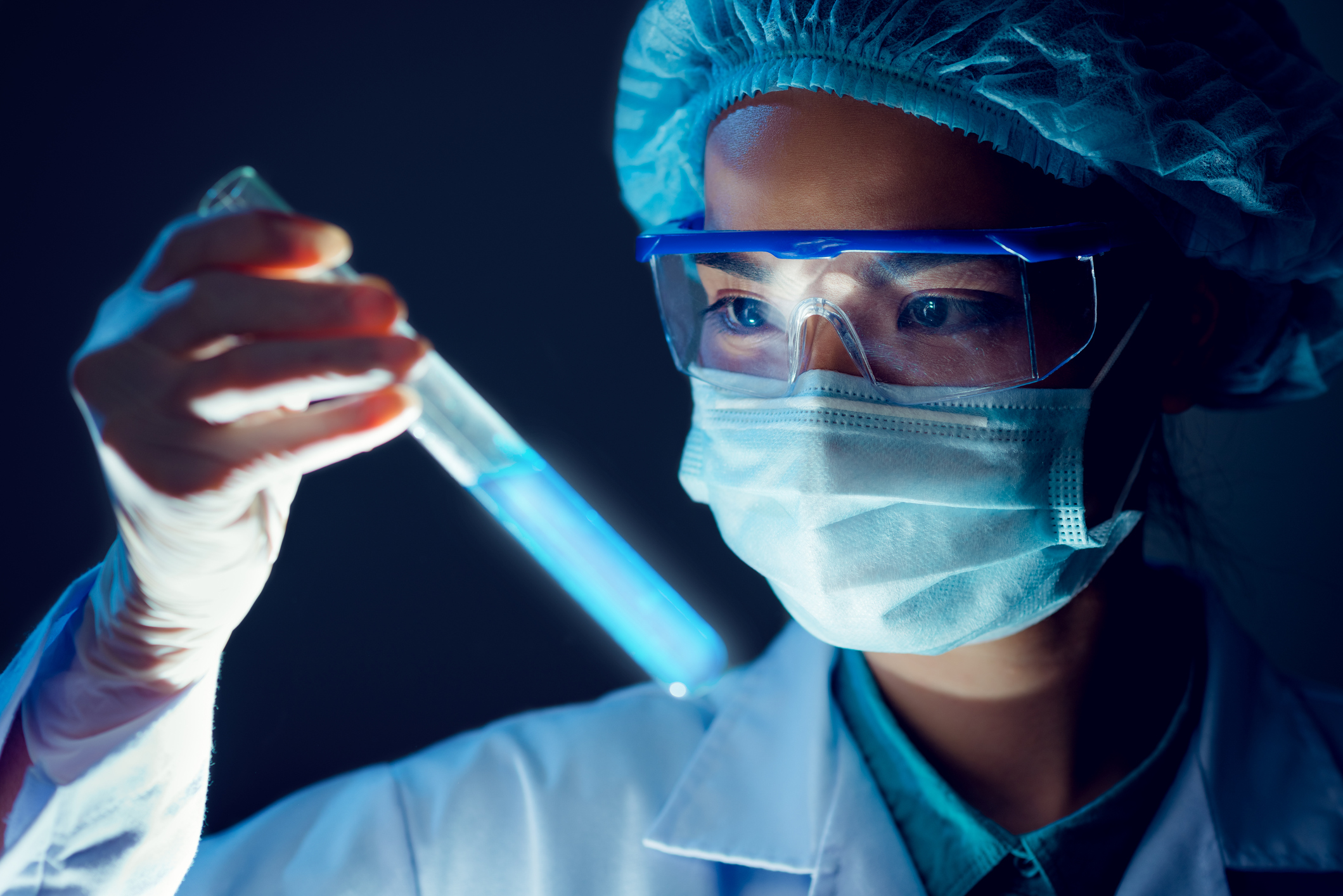 Medical researcher holding test tube with blue water liquid