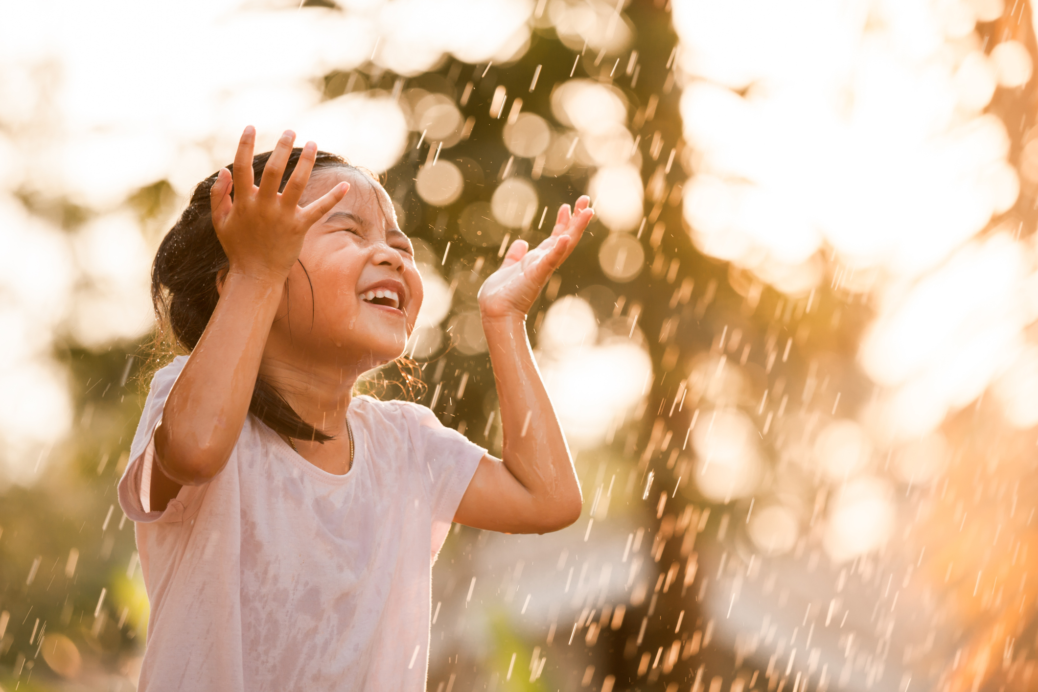 Happy asian little girl having fun to play with the rain in vintage color tone