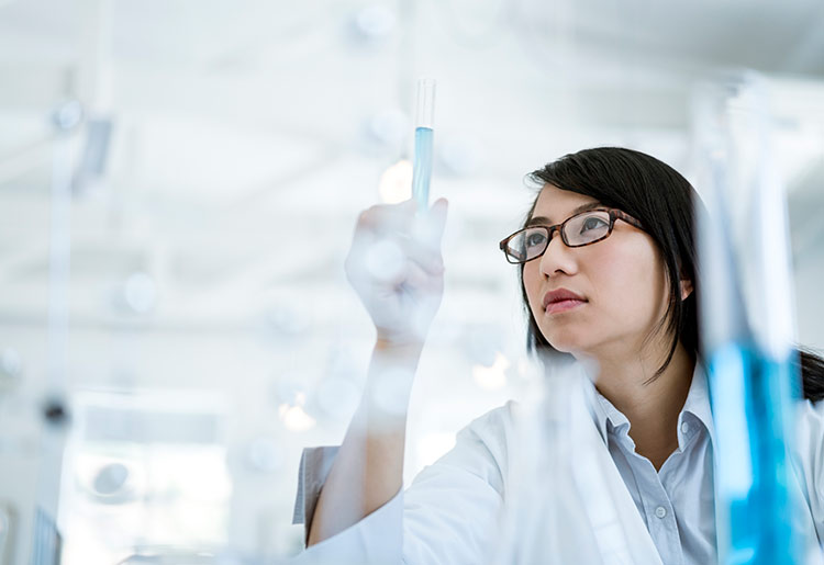 Frau im Labor prüft den Inhalt eines Reagenzglases
